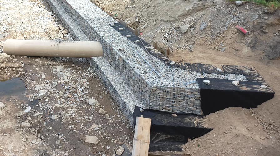 A geotextília elválasztó rétegként szolgál a gabion mögött a talaj és a kőkitöltés között